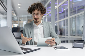 Professional young adult businessman concentrating at his workplace, showing dedication and...