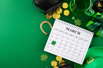 Gearing up for St. Patrick's festive spirit. Top view shot of calendar, leprechaun hat, gift, green...