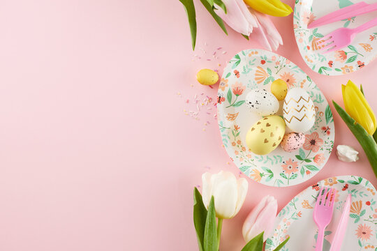 Egg-stravaganza fun: kids' Easter delight and joyful celebrations. Top view photo of cute plates, eggs, cutlery, tulips, rabbit, sprinkles on light pink background with space for greeting text