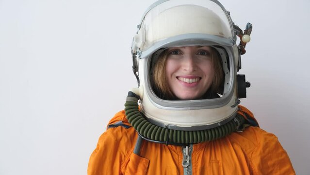 Happy woman astronaut wearing space suit open space helmet and smile. Girl power concept.