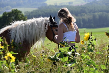 Durch dick und dünn. Junge Frau umarmt schönes Pferd