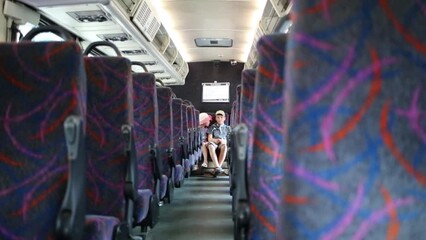 Boy and girl sitting in the back seat of an empty bus - Powered by Adobe