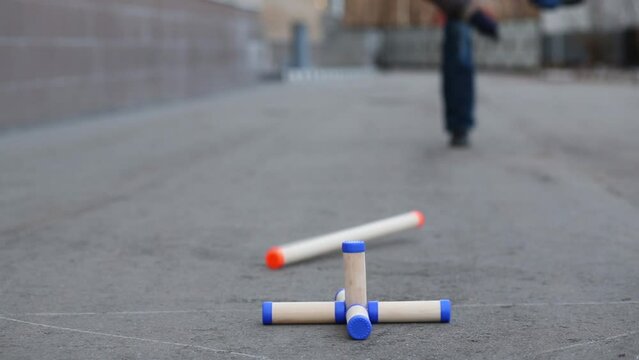 Legs men shooting down second time star figure in gorodki game.
