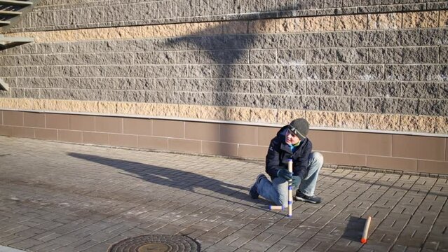 Boy puts five pins vertically when he plays gorodki game. 