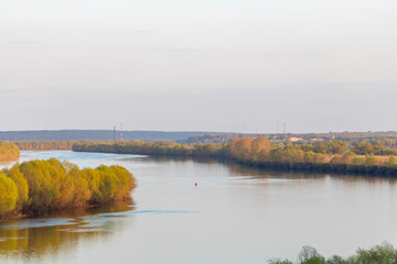Evening landscape, early spring, a bend of a wide river, a strip of forest on the horizon