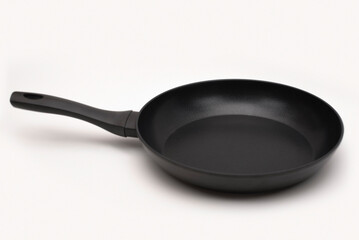 A large new pan on a light background with a dark shadow. A pan with high walls for frying or stewing food