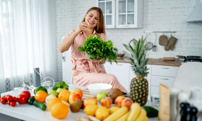 Woman Sitting on Kitchen Counter Surrounded by Fruits and Vegetables. A woman sits on a kitchen counter, surrounded by an assortment of fresh fruits and vegetables.