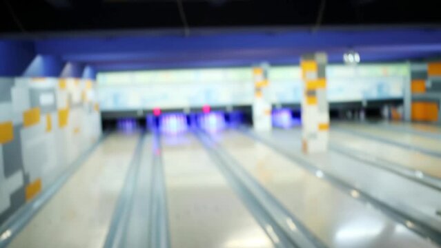 Girl raises a bowling ball, the camera moves to the scoreboard