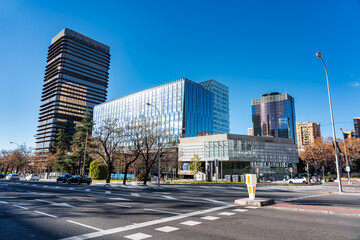 Modern office buildings that reflect other skyscrapers in Madrid in their windows.