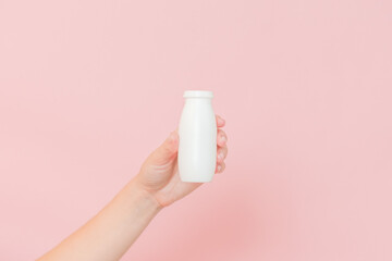 White bottle of probiotic yogurt for digestive system in hand. Dietary supplements for stomach