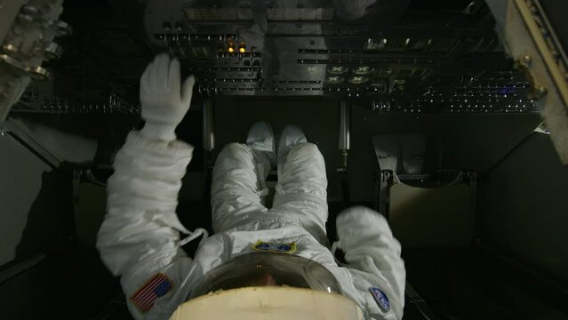 Astronaut in shuttle pushing buttons - high, steady cam shot