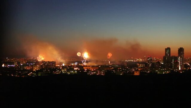 Beautiful bright fireworks show above big city at night