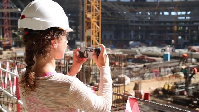 Woman in helmet photograph of construction site in stadium.