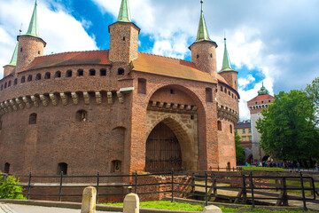 A round building of an old fortress with a red brick gate in the center of Krakow.