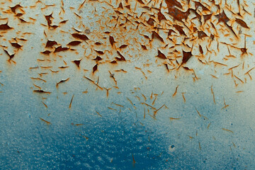 Close-up of chipping rust on a textured blue background