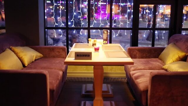 Reserved table with sofas and cushions in restaurant