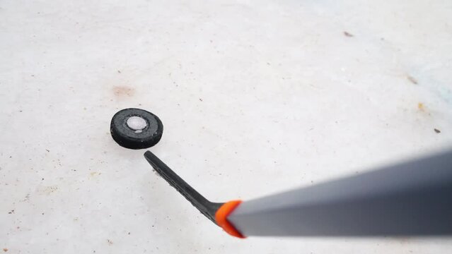 Puck and baton on ice rink during hockey game at winter