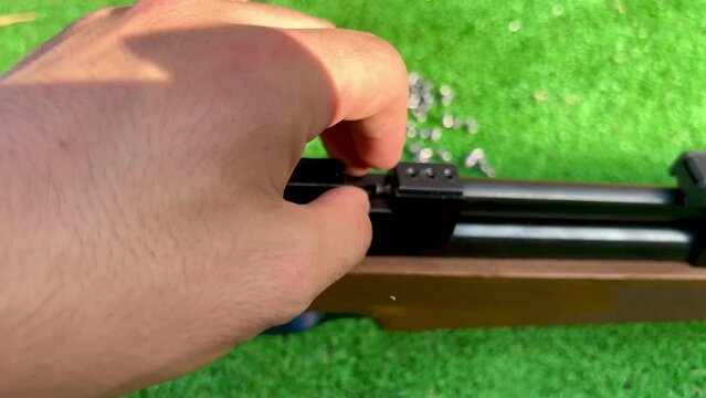 Video of a hand reloading a shotgun with pellets