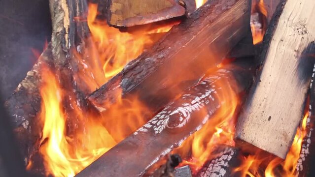 Close up of bright fire and firewood outdoor at winter
