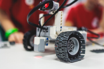 Group of diverse children kids with robotic vehicle model, close-up view on hands, science and...