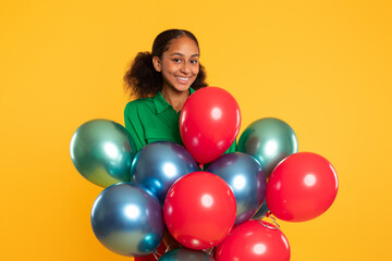Fototapeta na wymiar black teen girl posing with bunch of colorful balloons, studio
