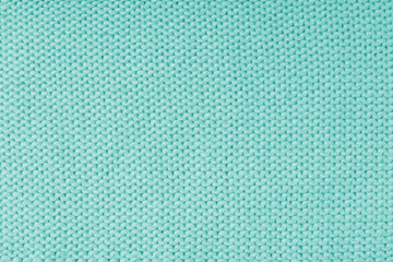 Close up background of knitted wool fabric made of viscose yarn, turquoise color wool knitwear texture. Sweater, pullover knitted jersey background. Fabric abstract backdrop, wallpaper