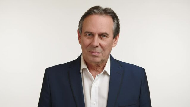 A mature man in a suit gives a head shake indicating 'no,' his demeanor showing disagreement or disapproval, with a subtle look of decision against a white background. Camera 8K RAW. 