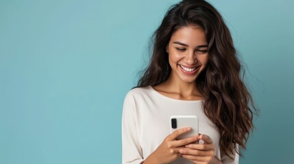 oung adult smiling happy pretty latin woman holding mobile phone looking at smartphone, typing message doing ecommerce shopping on cell, using trendy apps on cellphone isolated on blue background - obrazy, fototapety, plakaty