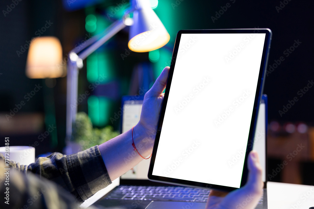 Poster closeup of an individual vertically holding digital device with blank white screen display. a person