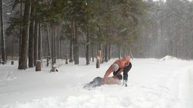 Two guys wrestle practicing hip throw at outdoor sportsground