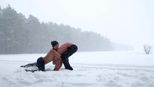 Two guys wrestle practicing holding at outdoor sportsground