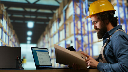 Shipping manager for operations verifies cargo details on files, ensuring right information for merchandise shipment and delivery. Staff member examines shipment tags at trade facility.