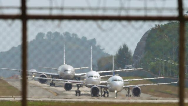 Planes on the taxiway one after another on queue after landing. Airfield, queue of jet planes, aviation. Travel concept