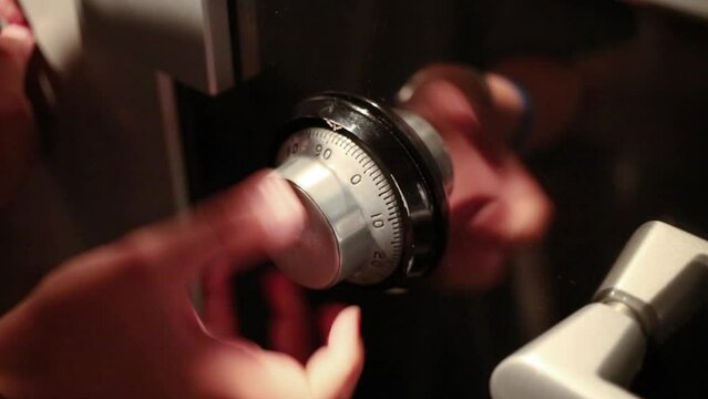 Little boy is turning the lock combination on strongbox.
