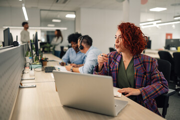 Hispanic woman working in a call center and using a laptop