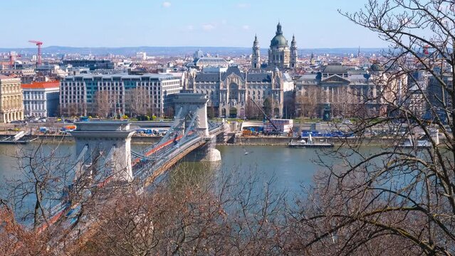 Secheni bridge with traffic. An ancient Secheni bridge with city traffic over Danube river against buildings in Budapest.
