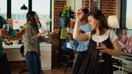 School colleagues celebrating summer vacation, organizing apartment party, enthusiastically dancing to Hiphop music. Joyful friends enjoying time spent together, busting into lively dance moves