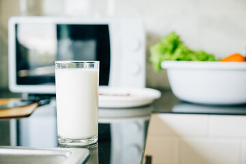 Fototapeta na wymiar Glass of milk on rustic kitchen table. Empty space for product display. Fresh morning drink for organic diet. Clean transparent jug nature protein source. Modern design give me. Healthy eating concept