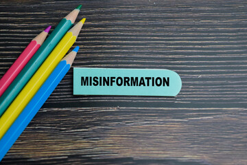 Concept of Misinformation write on sticky notes isolated on Wooden Table.