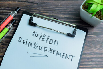 Concept of Tuition Reimbursement write on paperwork isolated on wooden background.