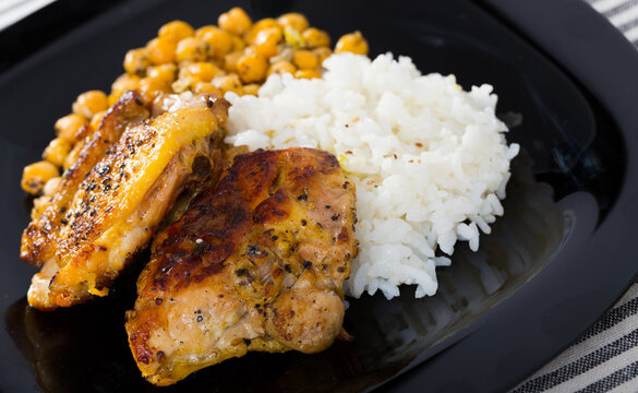 Image of tasty chicken thighs with cheakpea and rice at plate