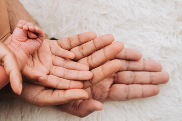 Family hands are stacking hands under the baby's hand