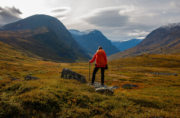 A hiker on her way along a valley in Swedish Lapland, Sweden, September