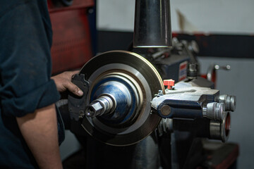 Mechanic grinding car brakes in workshop