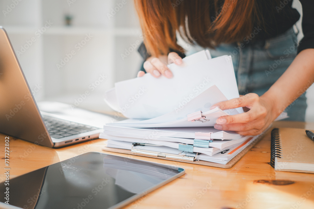 Poster businesswoman working in stacks of paper files for searching and checking unfinished document achiev