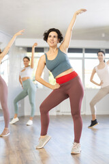 Obraz premium Female coach conducts classes in modern energetic dancing for young girls. Concept of active hobby, pleasant way to lose weight and maintain perfect figure