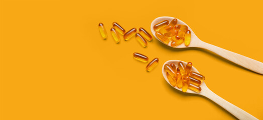 Spoons with fish oil capsules on orange background with space for text - obrazy, fototapety, plakaty