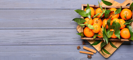 Tray of sweet tangerines on blue wooden background with space for text, top view