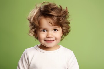 Portrait of a cute little girl with flying hair over green background