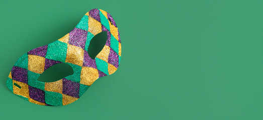 Carnival mask on green background with space for text